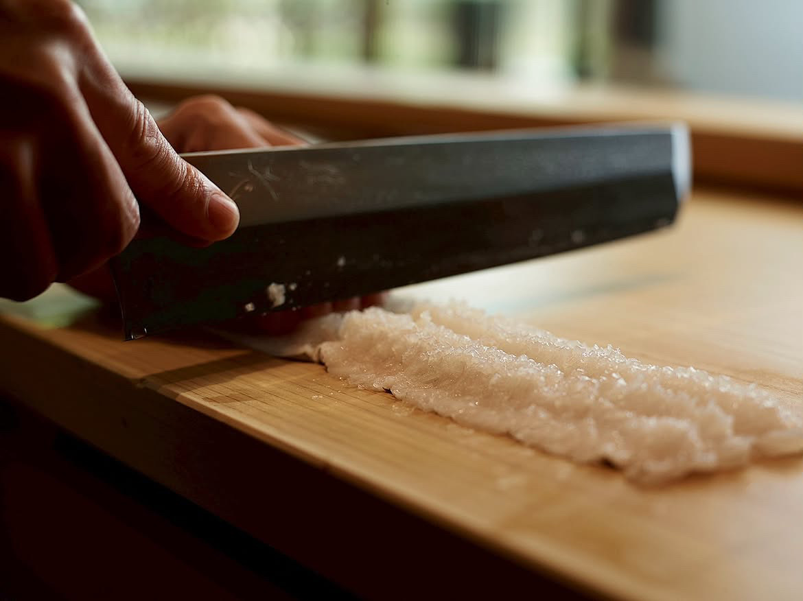 包丁で魚を仕込む手元
